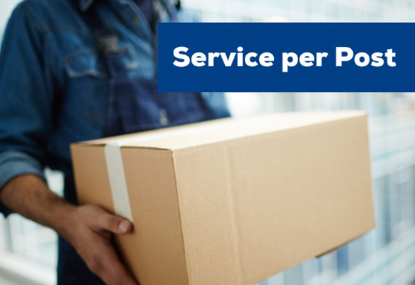 Ein Mitarbeiter in blauer Arbeitskleidung hält einen großen Pappkarton vor dem Oberkörper. Im oberen rechten Bildbereich steht auf dunkelblauem Hintergrund in weißer Schrift „Service per Post“.