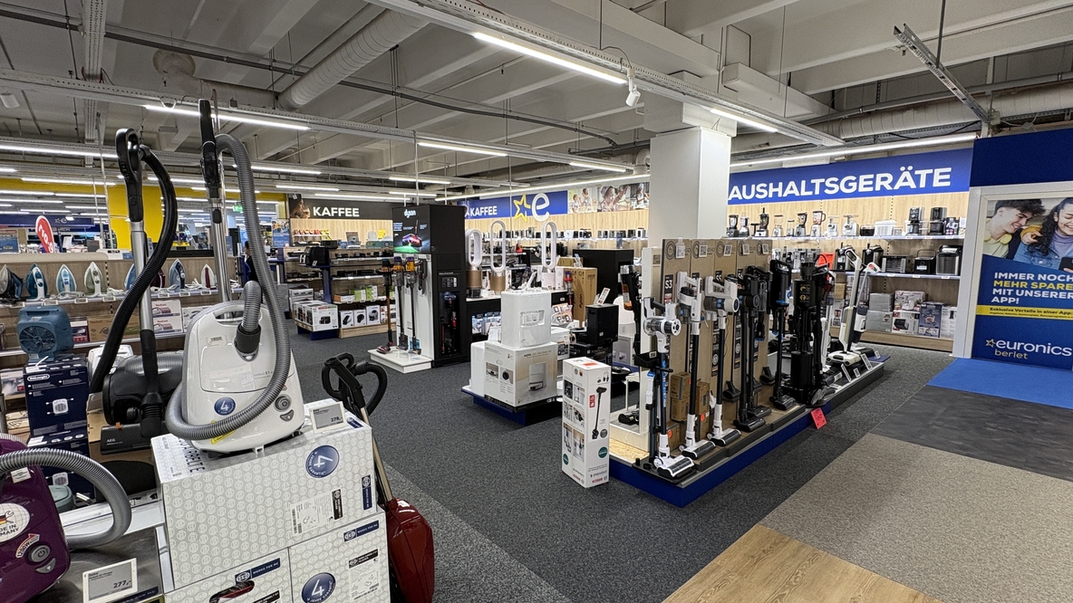 Innenansicht der EURONICS-Berlet-Unna-Haushaltsgeräteabteilung mit Staubsaugern im Vordergrund, rechts Reihen von Akku-Staubsaugern, im Hintergrund Regale mit weiteren Kleingeräten und Kaffeemaschinen. Innenansicht der EURONICS-Berlet-Unna-Haushaltsgeräteabteilung mit Staubsaugern im Vordergrund, rechts Reihen von Akku-Staubsaugern, im Hintergrund Regale mit weiteren Kleingeräten und Kaffeemaschinen.