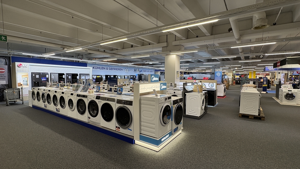 Große Weißwarenabteilung im EURONICS-Berlet-Markt mit langen Reihen ausgestellter Waschmaschinen und Trockner im Vordergrund und Kühl- und Gefriergeräten im Hintergrund. Große Weißwarenabteilung im EURONICS-Berlet-Markt mit langen Reihen ausgestellter Waschmaschinen und Trockner im Vordergrund und Kühl- und Gefriergeräten im Hintergrund.