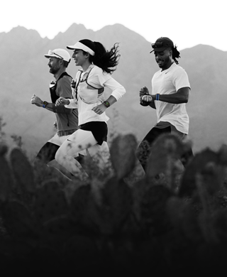 Drei Personen laufen in einer Berglandschaft, alle tragen die Apple Watch Ultra 3