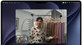 Ein Videoanruf auf einem MacBook Pro, in dem eine Frau zwei Personen Stoffe zeigt, während die Automatische Ausrichtung dafür sorgt, dass sie in der Mitte des Bildes bleibt, auch wenn sie sich durch den Raum bewegt