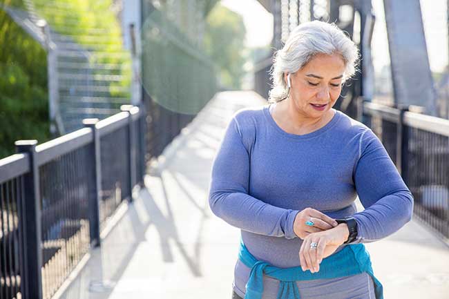 Ältere Frau benutzt Fitness-Tracker mit grundlegenden Funktionen