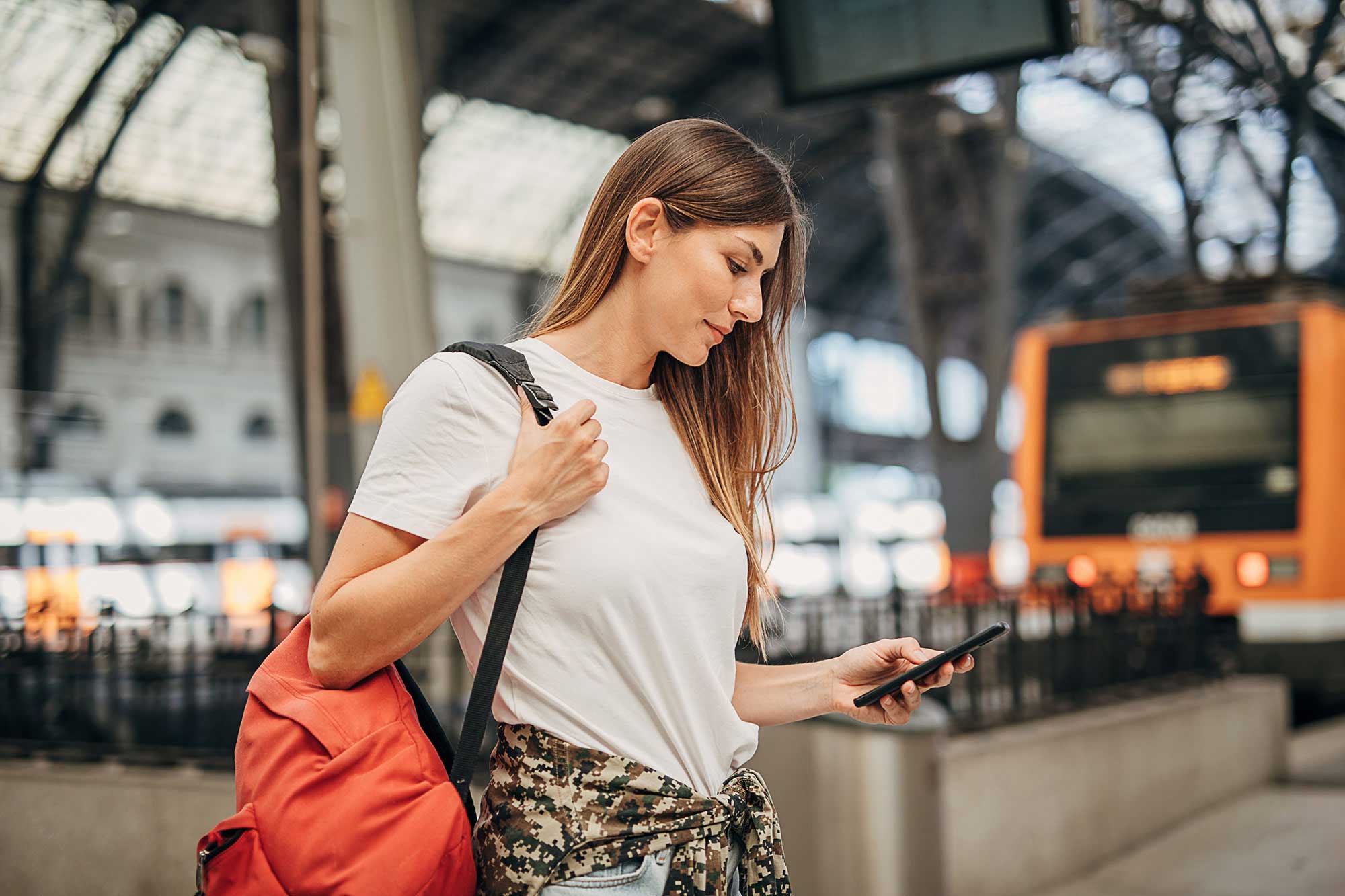 Frau benutzt unterwegs ihr Smartphone