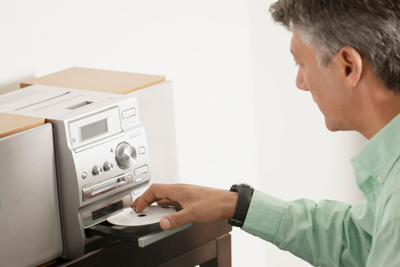 Ein Mann legt eine CD in einen CD-Player ein