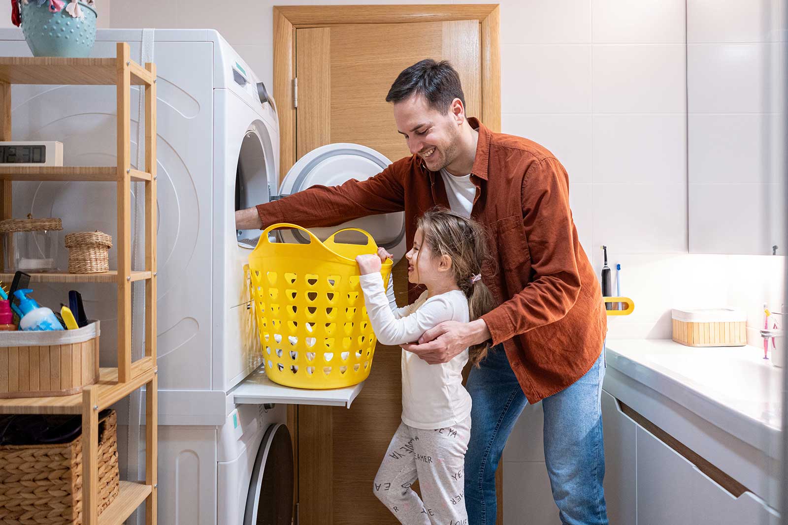 Vater und Tochter holen Wäsche aus dem Trockner