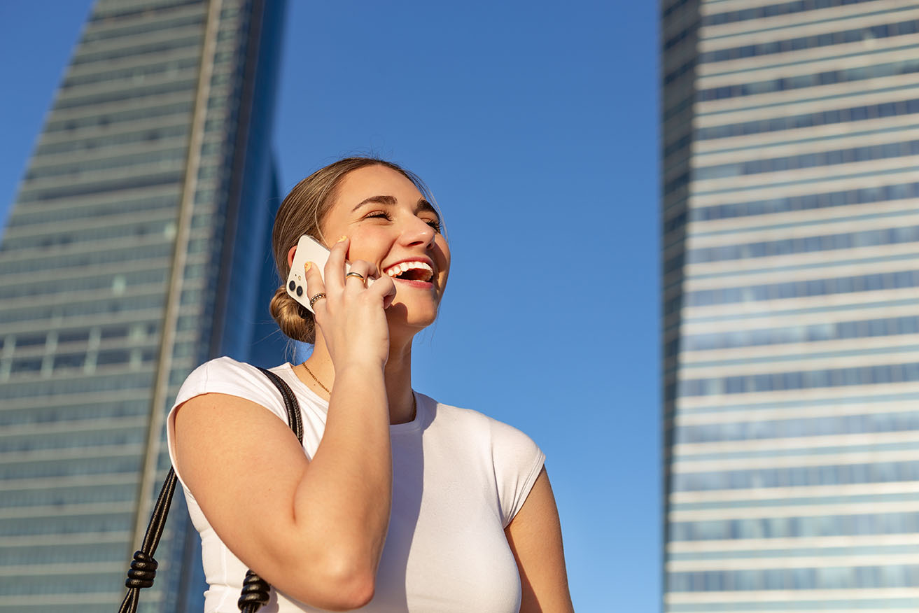 Lächelnde Frau telefoniert mi iPhone